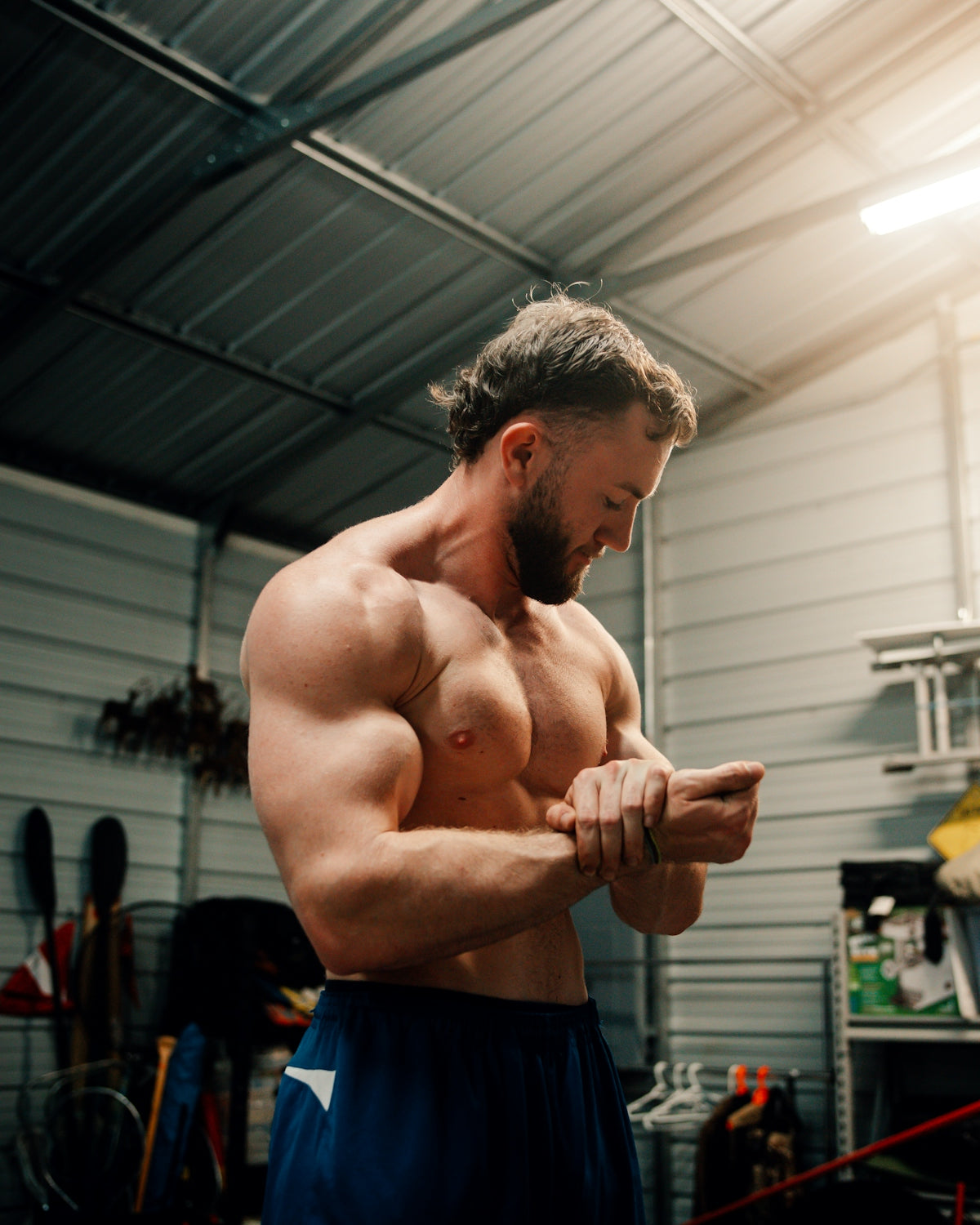 a man in a garage flexing his muscles