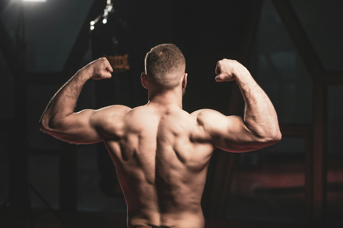 a man flexing his muscles in a gym