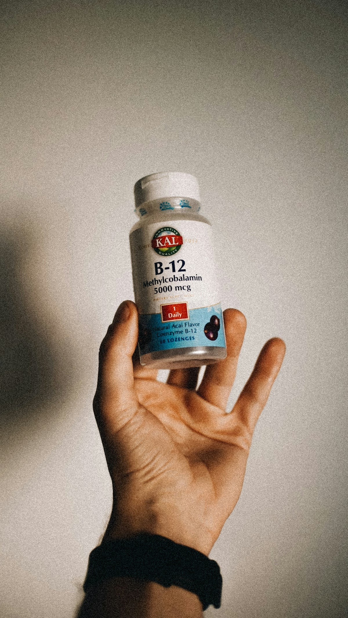 a person holding a bottle of vitamins in their hand