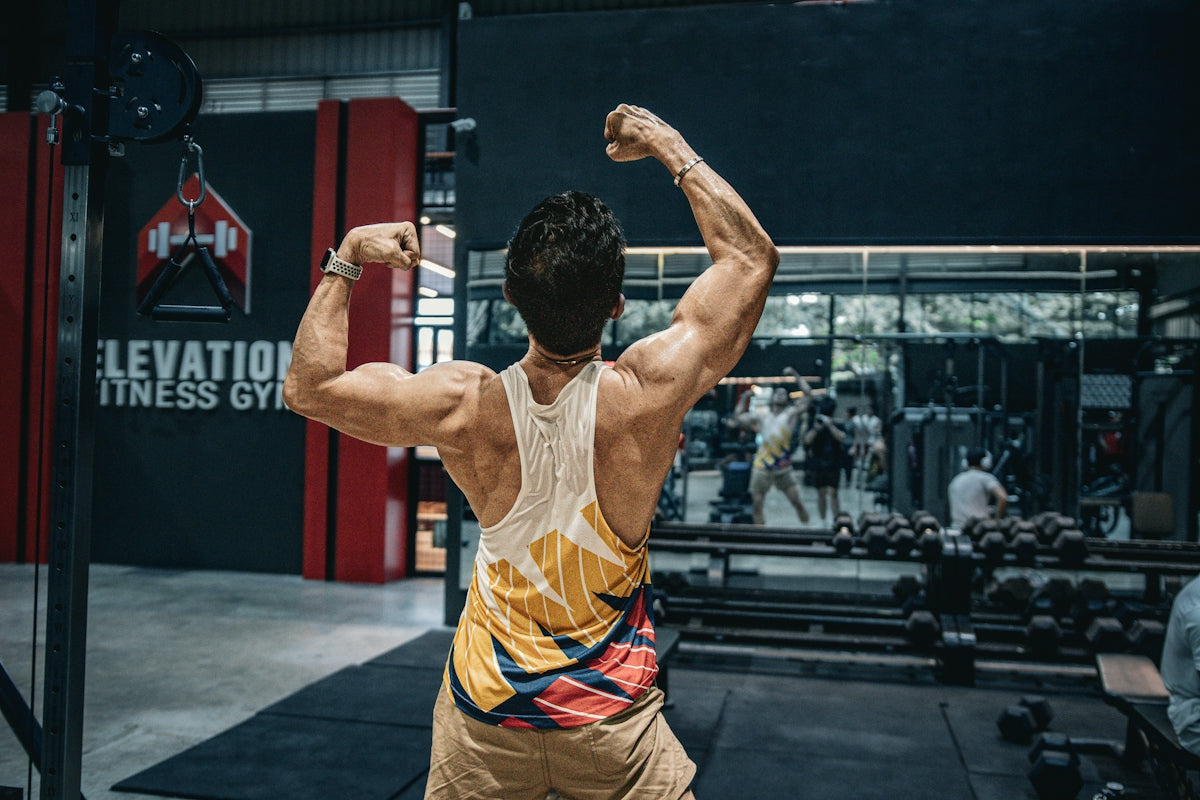 Man flexes muscles in a gym