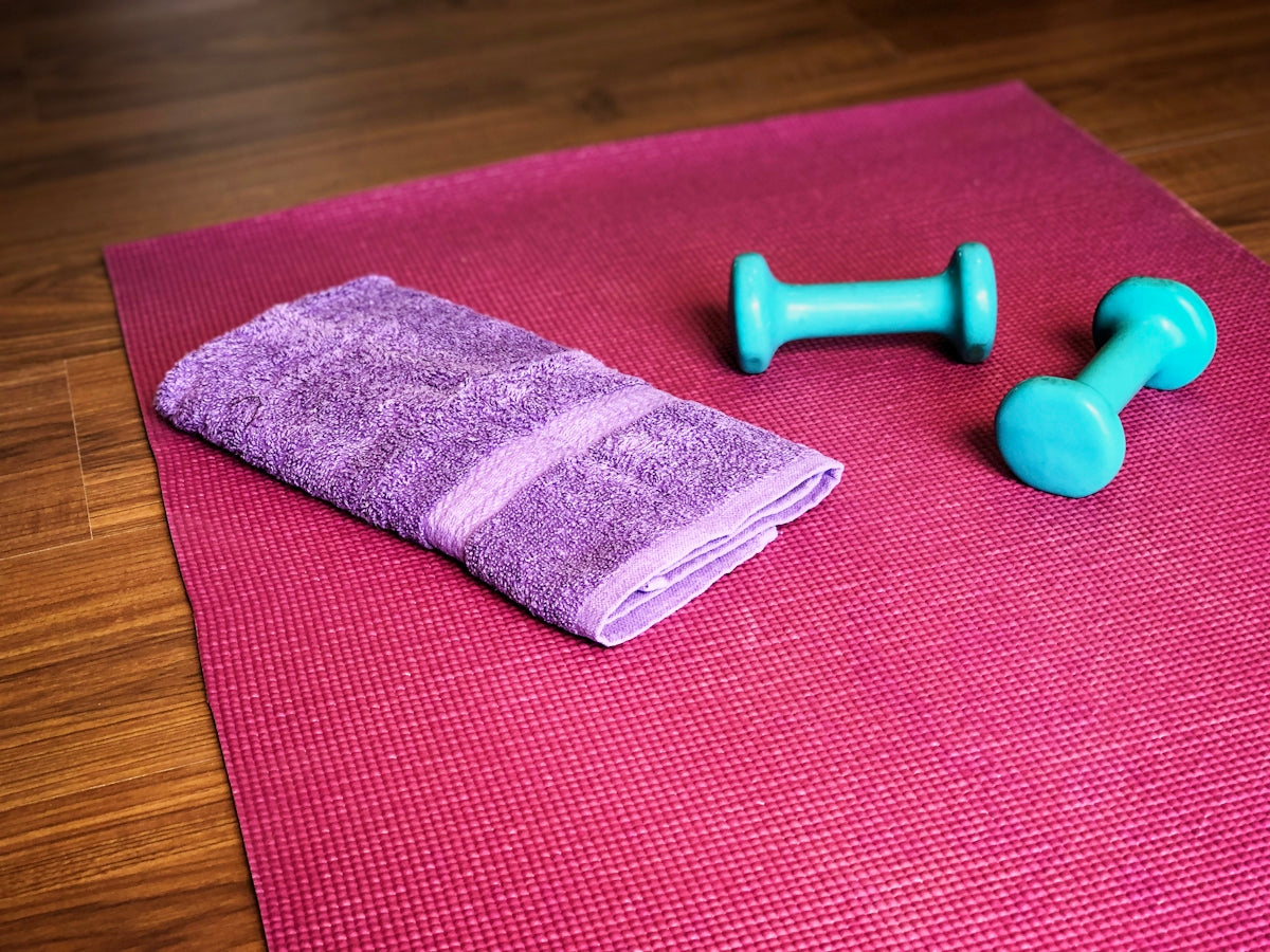Yoga mat, weights, and a towel ready for a workout.